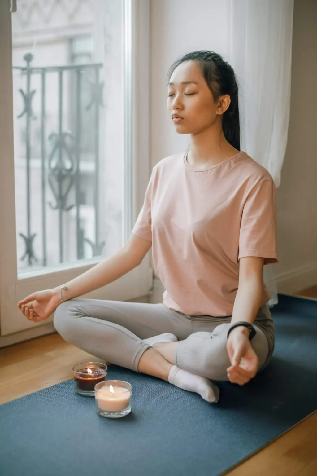 Eine brennende Kerze auf einer Hand als Vorbereitung für Meditation.