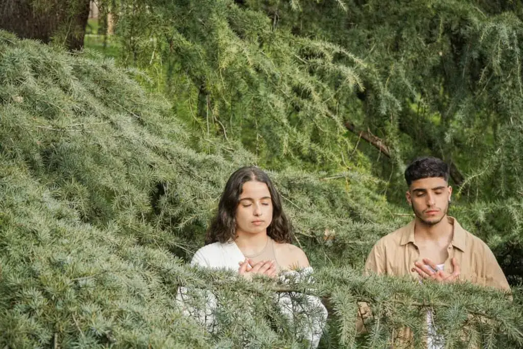 Zwei Jugendliche, die umgehen von grünen Bäumen Dankbarkeitsmeditation machen.